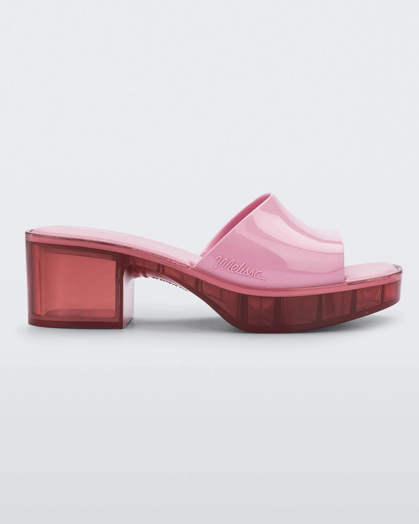 Side view of a Melissa Shape slide with transparent pink platform heel and a pink wide front strap. 