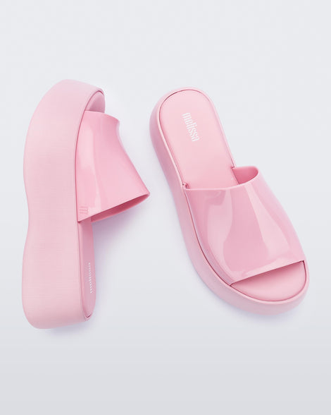 Top and side view of a pair of pink Melissa Becky platform slides. 