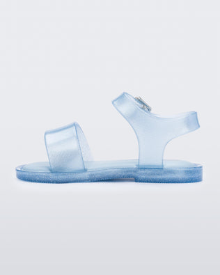 An inner side view of a blue glitter Mini Melissa Mar Sandal with two straps and a metal buckle.