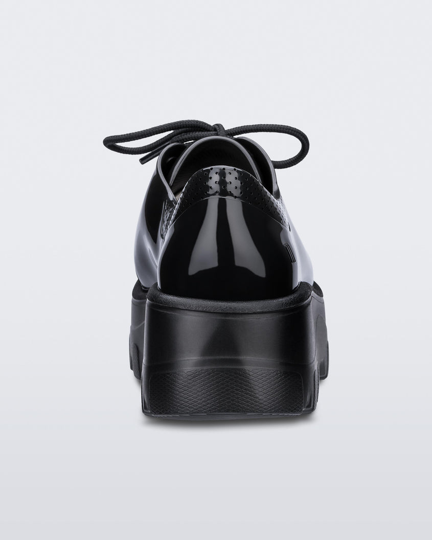 Back view of a black platform Melissa Kick Off Sneakers with laces.