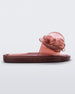Side view of a red Melissa Flower Beach slide with flowers on the top.