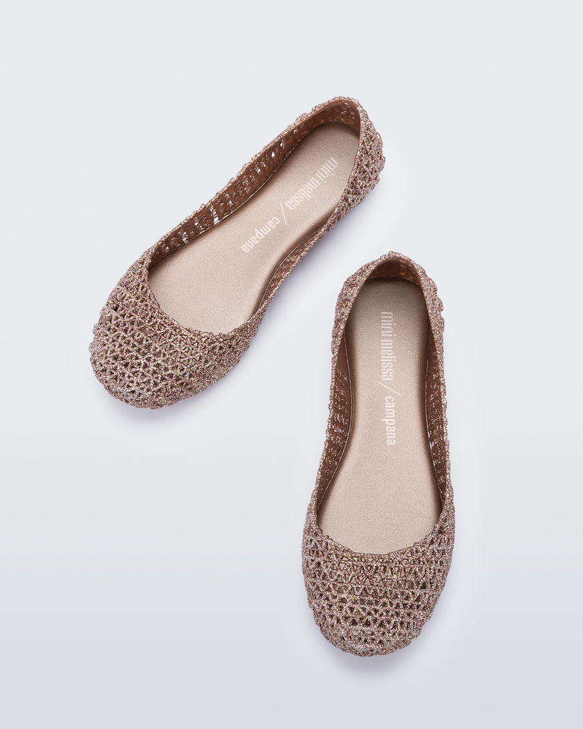 Top view of a pair of pink metallic Mini Melissa Campana flats with a woven design base.