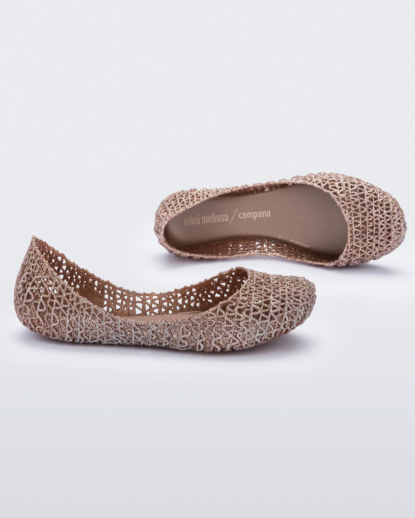 A side and top view of a pair of pink metallic Mini Melissa Campana flats with a woven design base.