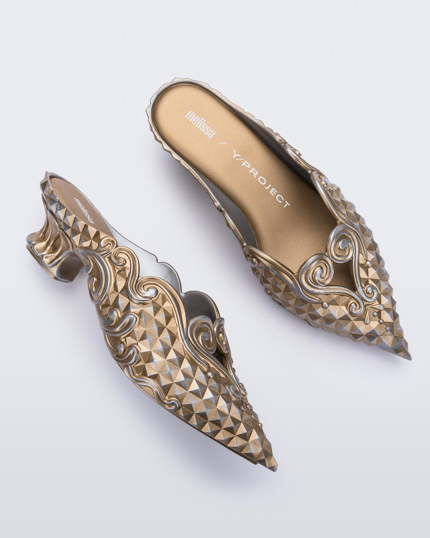 Top and side view of a Melissa Court mule with gold and silver coloring, a kitten heel and diamond- like pattern. 