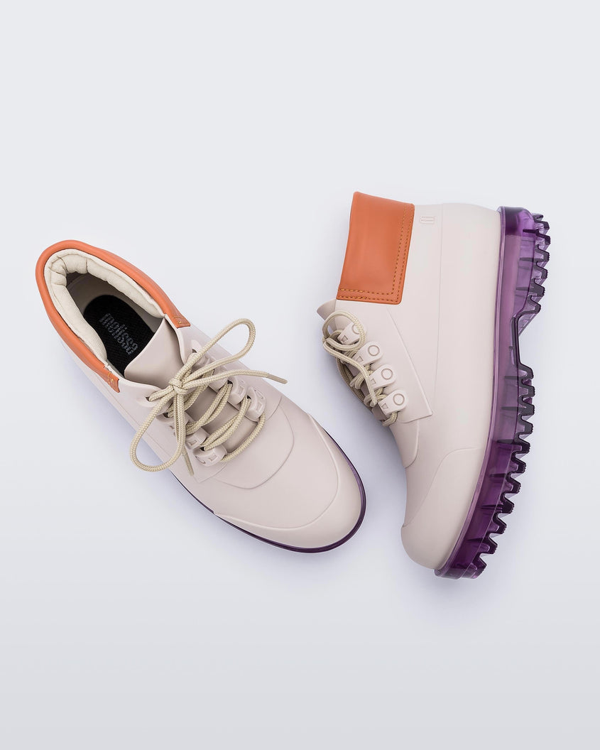 A top and side view of a pair of beige/orange/lilac Melissa Ares combat boots with a beige base, beige laces, orange top back and translucent lilac sole.