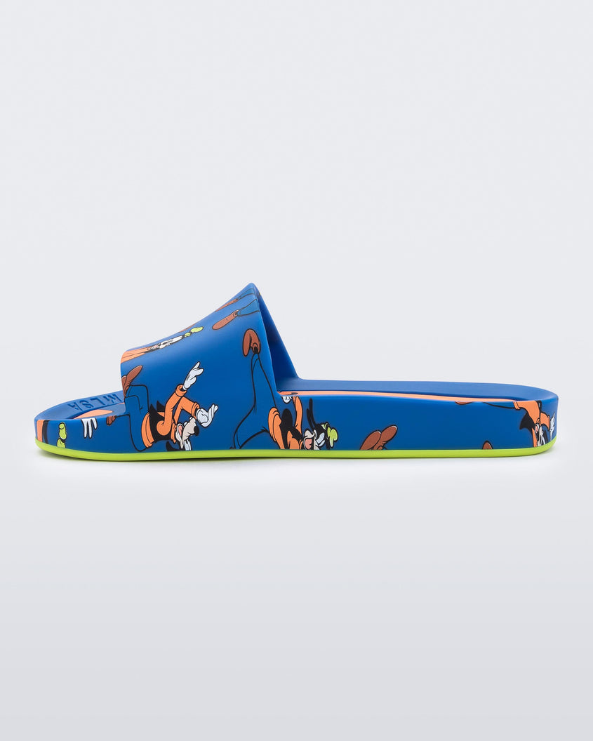 An inner side view of a blue Mini Melissa Beach slides with a blue base and a pattern of Disney's Goofy in different poses.