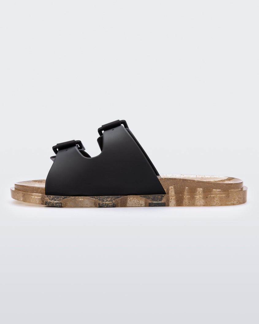 An inner side view of a Black/Beige Mini Melissa Wide Slide with a black top with two black buckles and a beige sole.