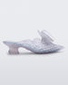 SIde view of a Melissa Flower Court mule in clear with kitten heel and a 3D flower above the toe