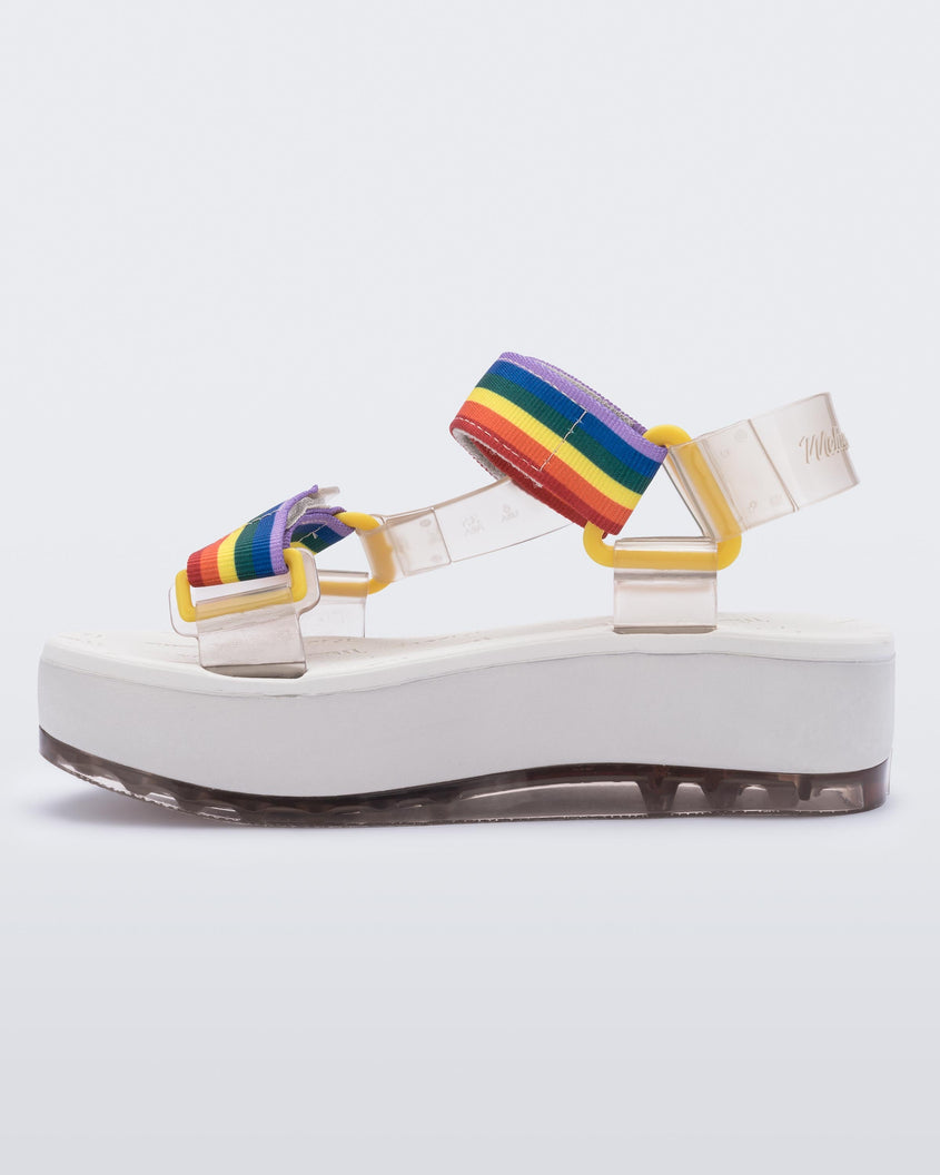 An inner side view of a white Melissa Papete Platform sandal with clear and rainbow straps.