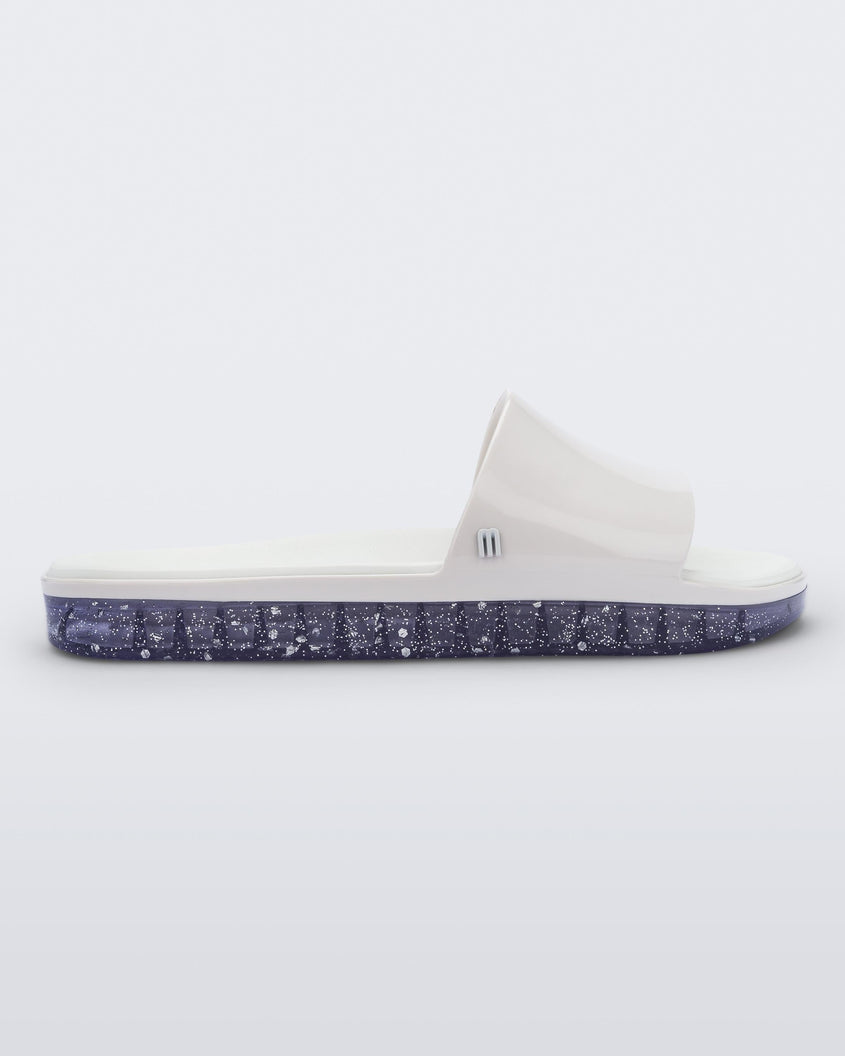 Side view of a white Melissa Beach slide with clear/glitter sole. 