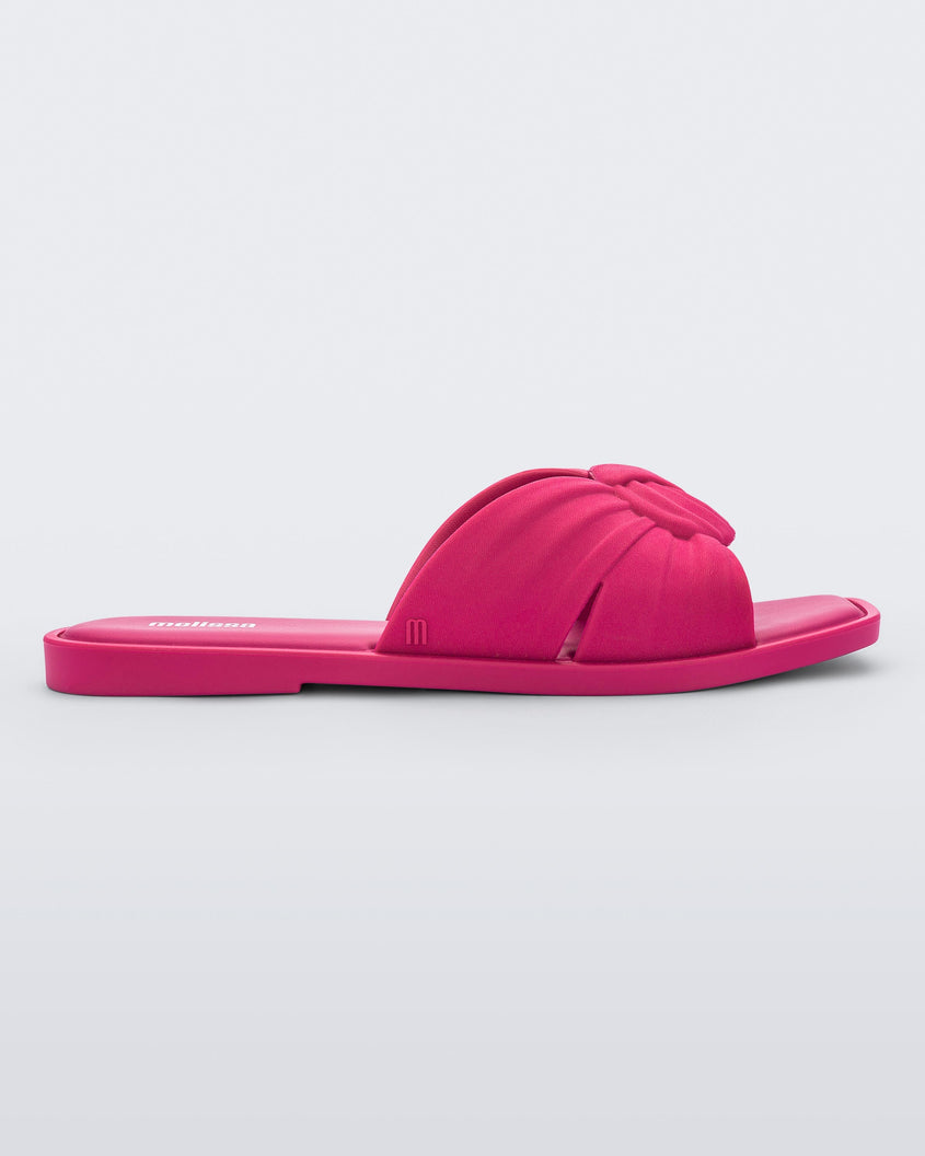 An outter side view of a pink Melissa Plush slide with a twist front strap detail.