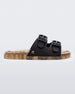 An outter side view of a Black/Beige Mini Melissa Wide Slide with a black top with two black buckles and a beige sole.
