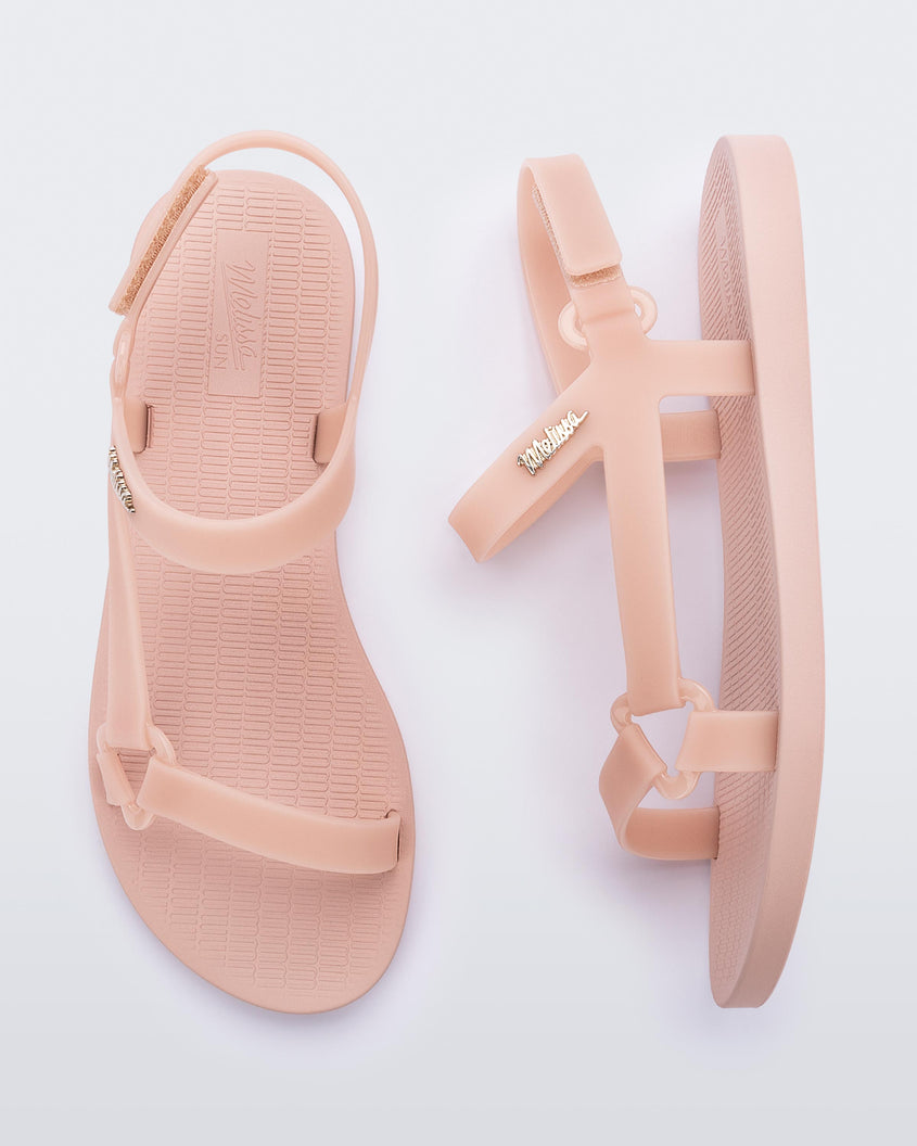 Top and side view of a pair Melissa Sun Downtown sandals with pink front cross and back ankle straps and a pink sole. 