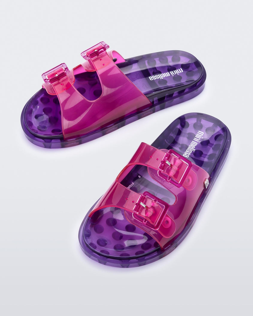 An top view of a pair of pink/lilac Mini Melissa Wide Slides with a pink top with two pink buckles and a lilac sole.