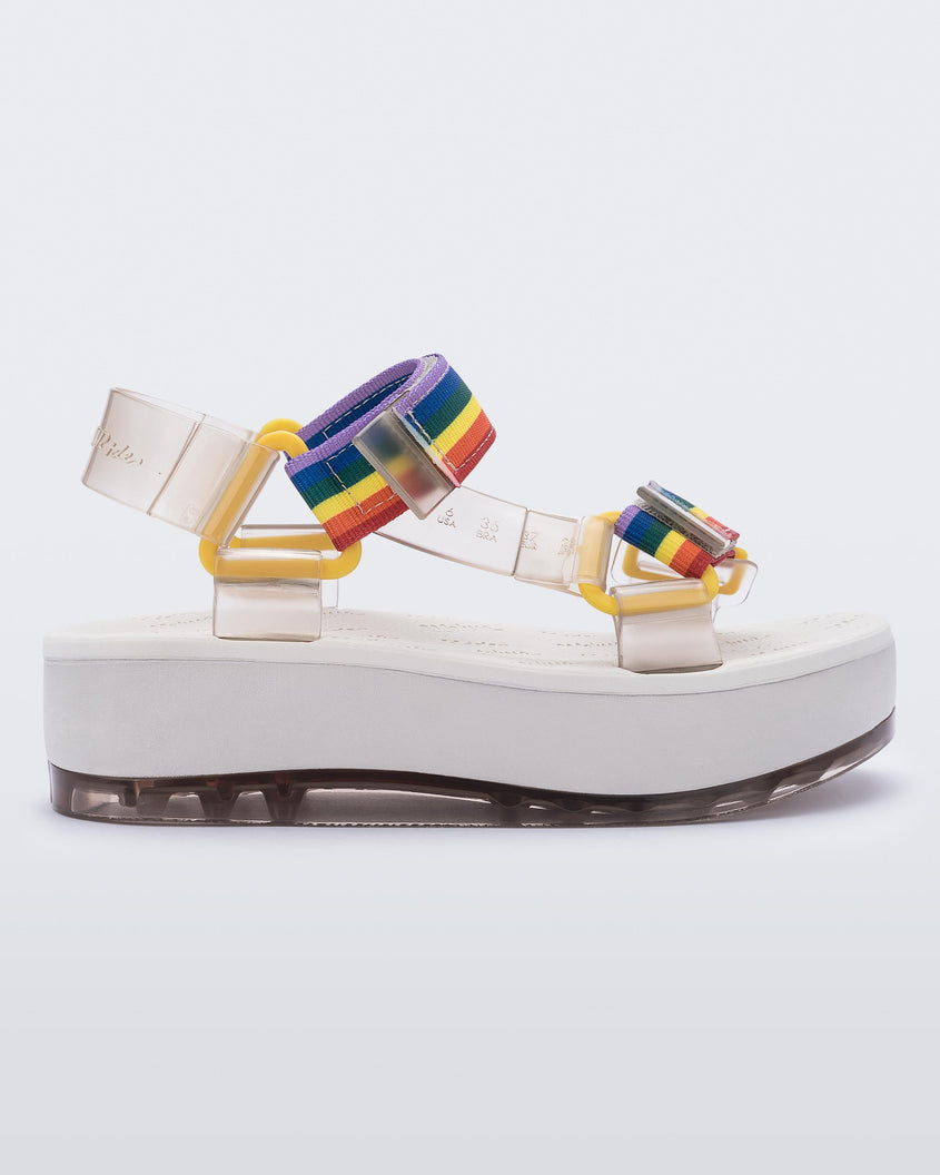 An outter side view of a white Melissa Papete Platform sandal with clear and rainbow straps.