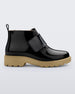 An outter side view of a black/beige Mini Melissa Chelsea boot with a black base, black velcro front strap and beige sole.