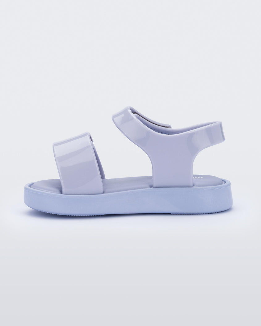 An inner side view of a purple Melissa Jump sandal with velcro straps.