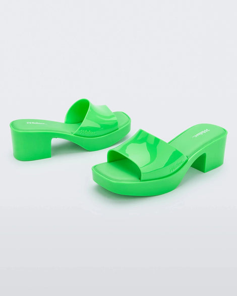 Angled front and back view of a pair of Melissa Shape platform slides in Green.
