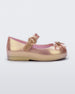 An outter side view of a pink Mini Melissa Sweet Love flat with a top strap and a bow detail on the toe.