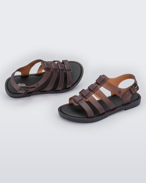 A top and side view of a pair of clear brown Melissa Flox sandals with straps.