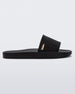 Side view of a Melissa Sun Sunset slide sandal in black with gold Melissa logo on the top side corner of the strap. 