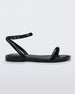 An outter side view of a black Melissa Wave Sandal with one front strap and one ankle strap.