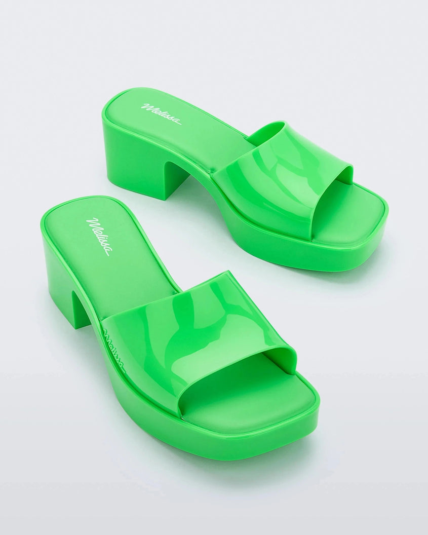 Angled view of a pair of Melissa Shape platform slides in Green.