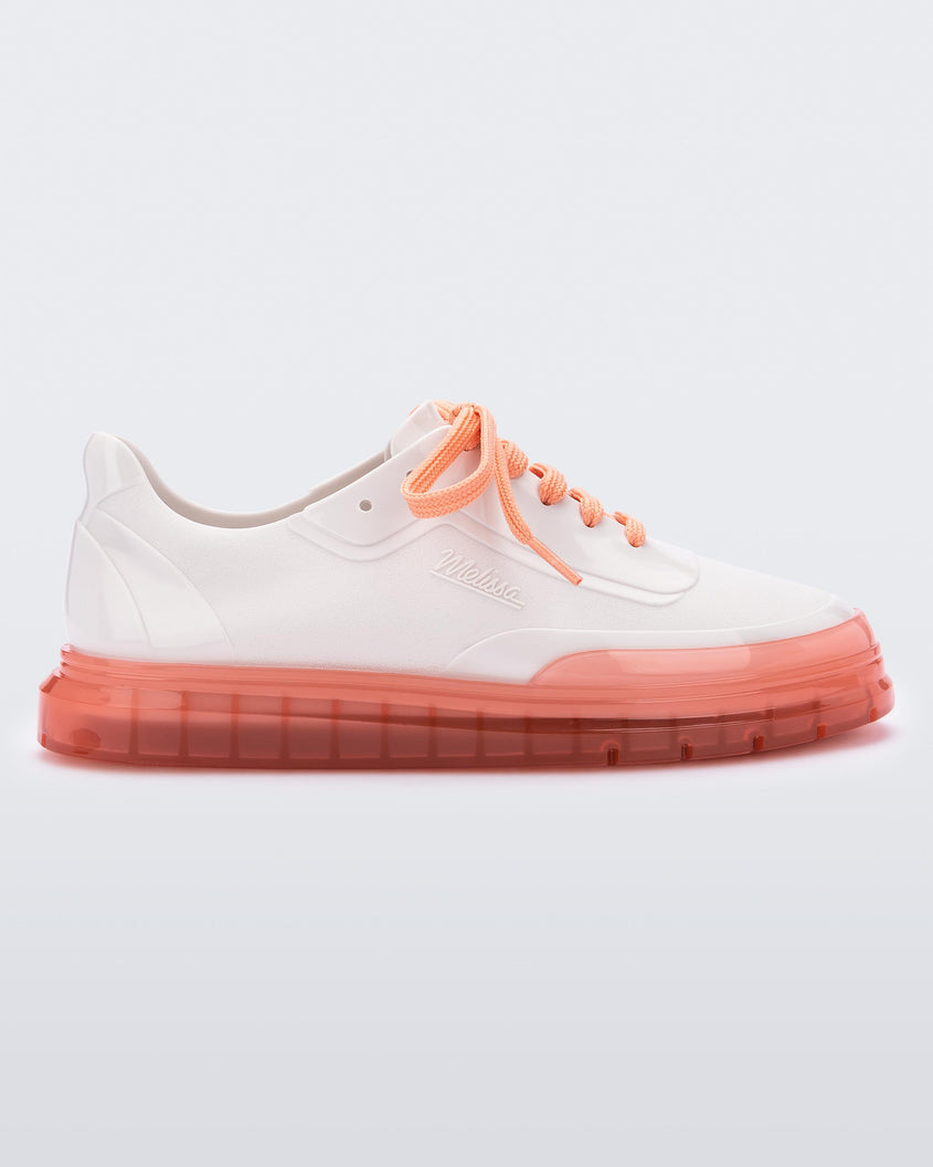 Side view of a white Melissa Classic sneaker with a white base, laces, orange sole and a melissa logo on the side.