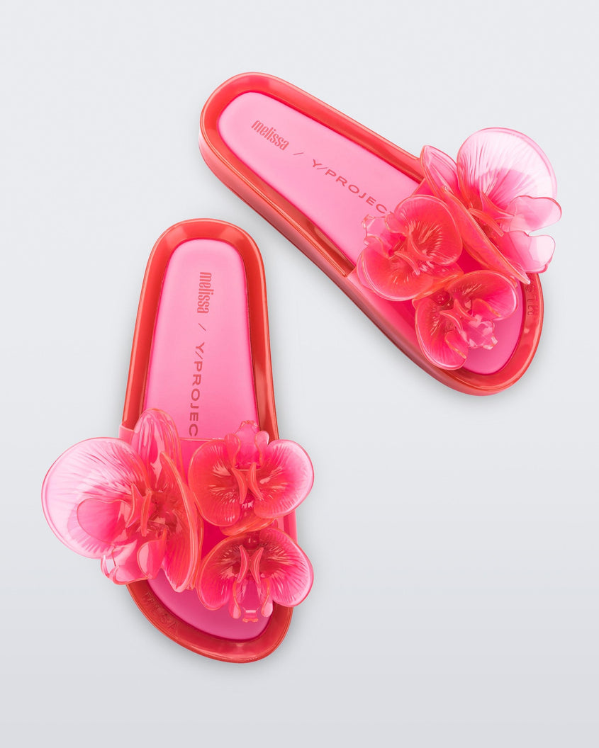 Top view of a pair of pink Melissa Flower Beach slides with flowers on the top.