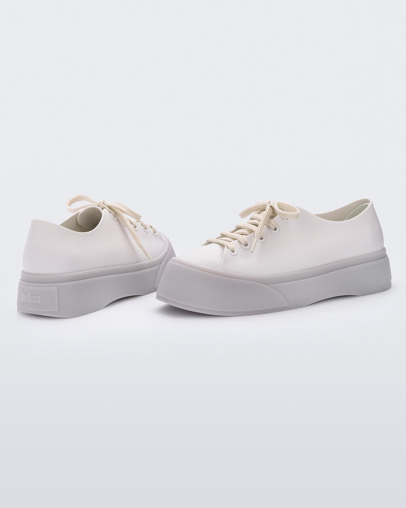 Back and side view of a beige Drive sneaker