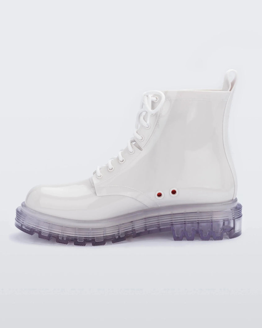 An inner side view of a pair of white/clear Melissa Coturno boot with a white base, laces and a clear sole.