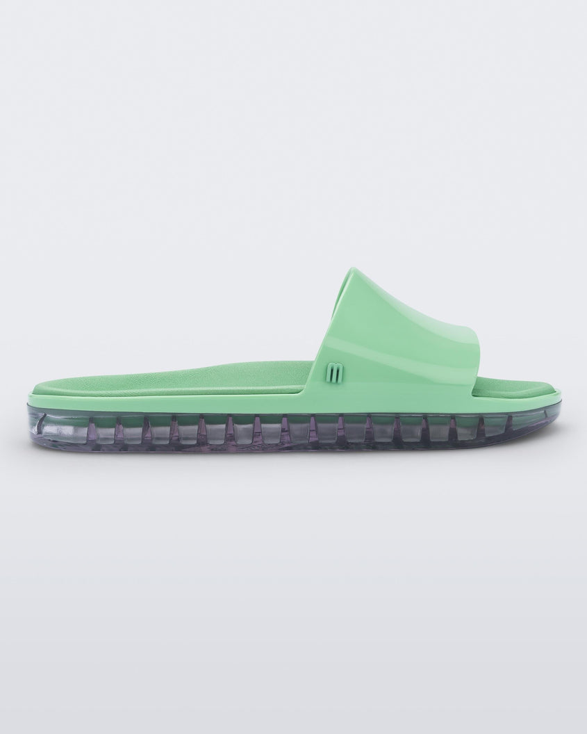 Side view of a green Melissa Beach slide with clear sole. 