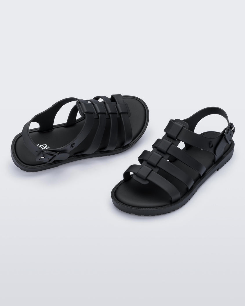 A top and side view of a pair of black Melissa Flox sandals with straps.