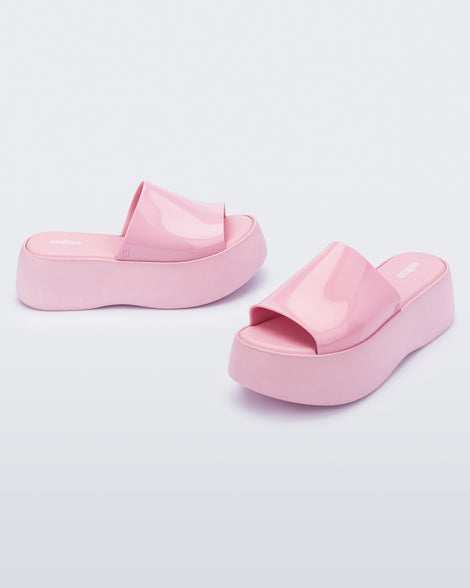 Angled view of a pair of pink Melissa Becky platform slides. 