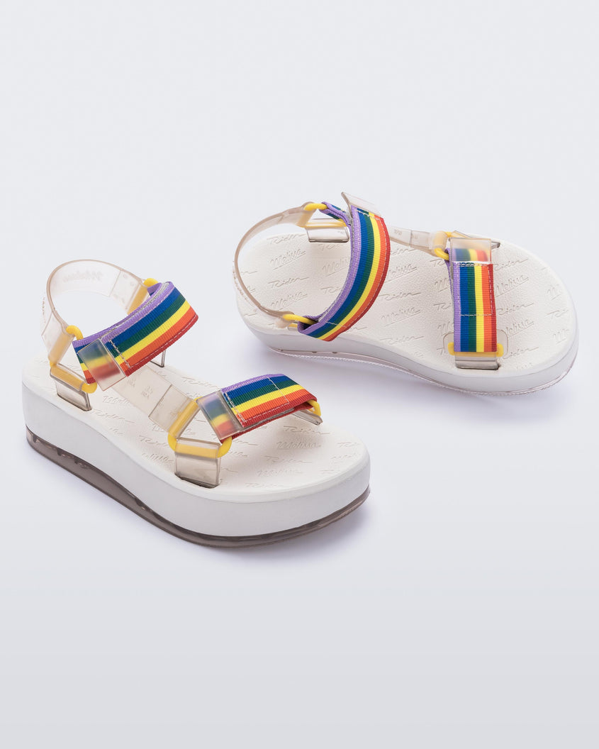 An angled front and top view of a white Melissa Papete Platform sandals with clear and rainbow straps.