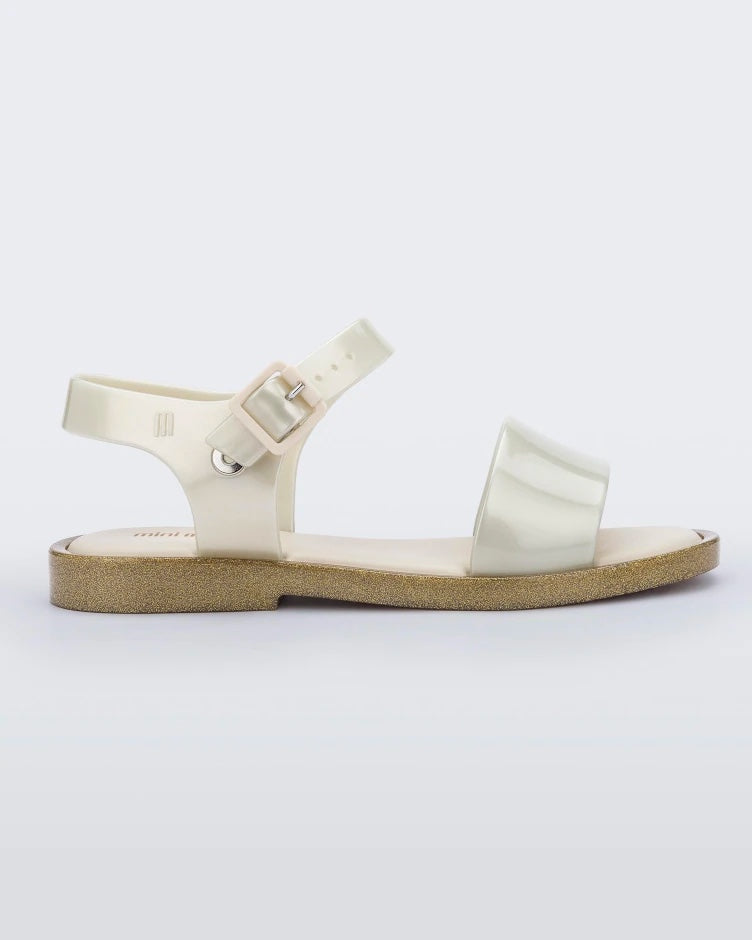 Side view of a beige Mini Melissa Mar Sandal with gold glitter outsole.