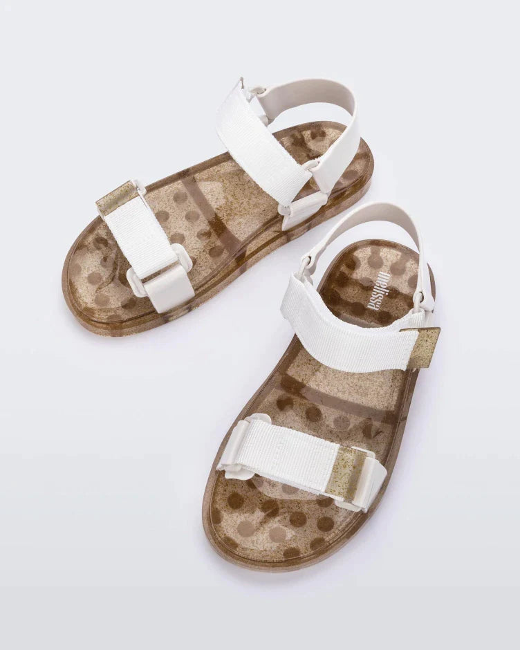 Top view of a pair of Melissa Wide Papete sandals with gold glitter sole and white velcro straps