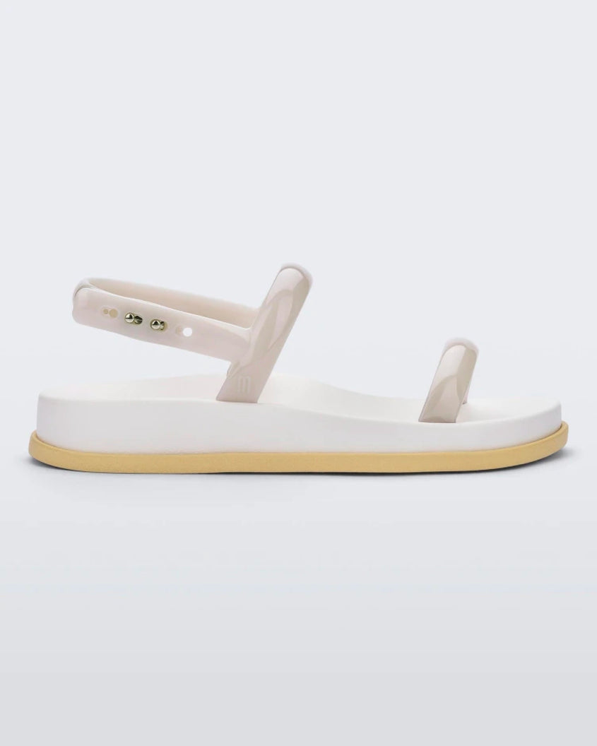 Side view of a beige/white/yellow Melissa Soft Wave Sandal with two front straps and an ankle strap.